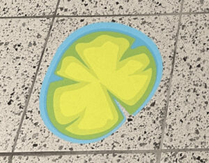 Colorful four-leaf clover-shaped sensory path on tiled floor.